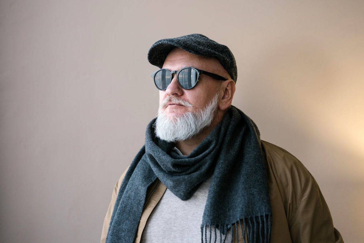 Old bald man with beard, sunglasses and a hat