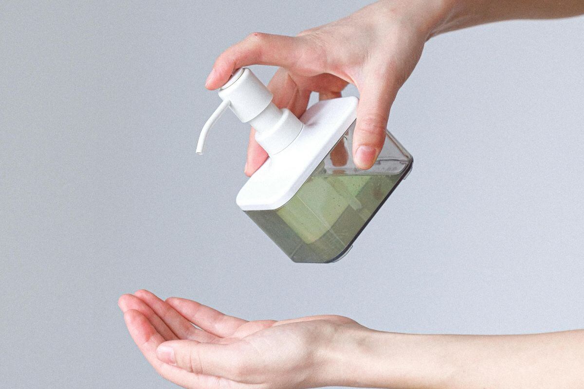 transition from antibacterial to natural hand soap. Hands with a bottle of liquid hand soap